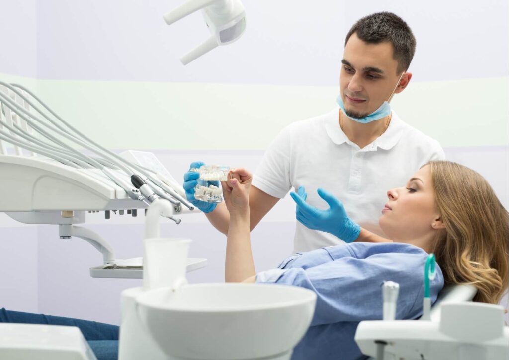 Dentist explaining dental implant treatment options to a patient during a consultation about dental implant costs.