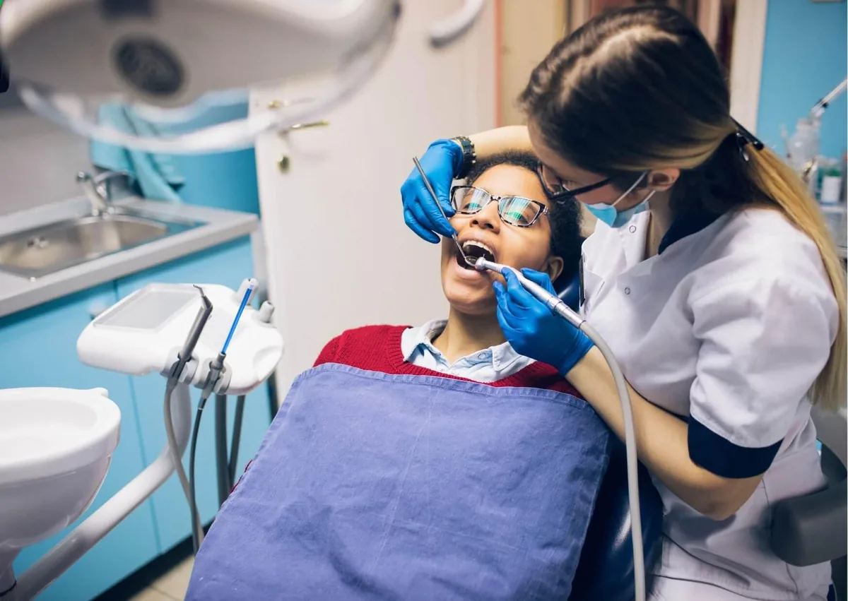 Dentist examining a patient&rsquo;s teeth before a dental bonding procedure.