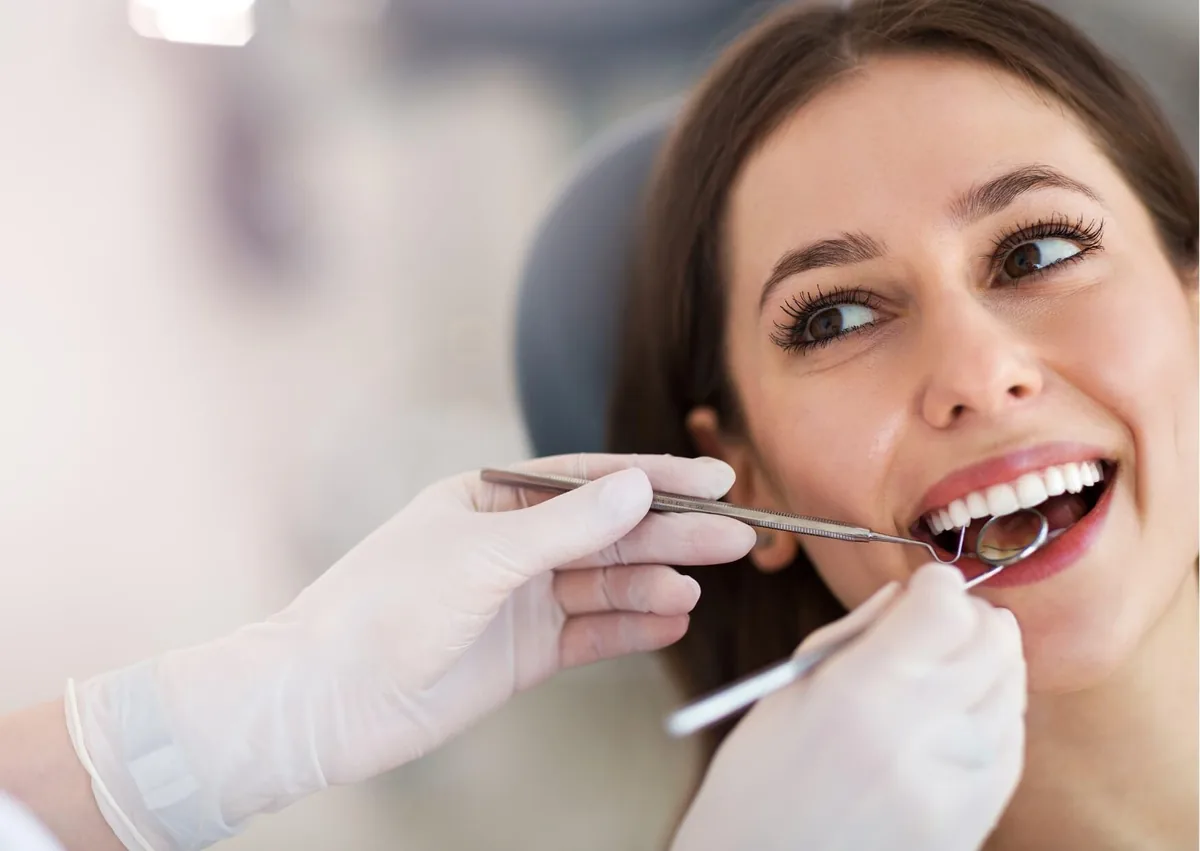 Dentist examining a patient’s teeth while planning a smile makeover to improve her smile’s appearance.